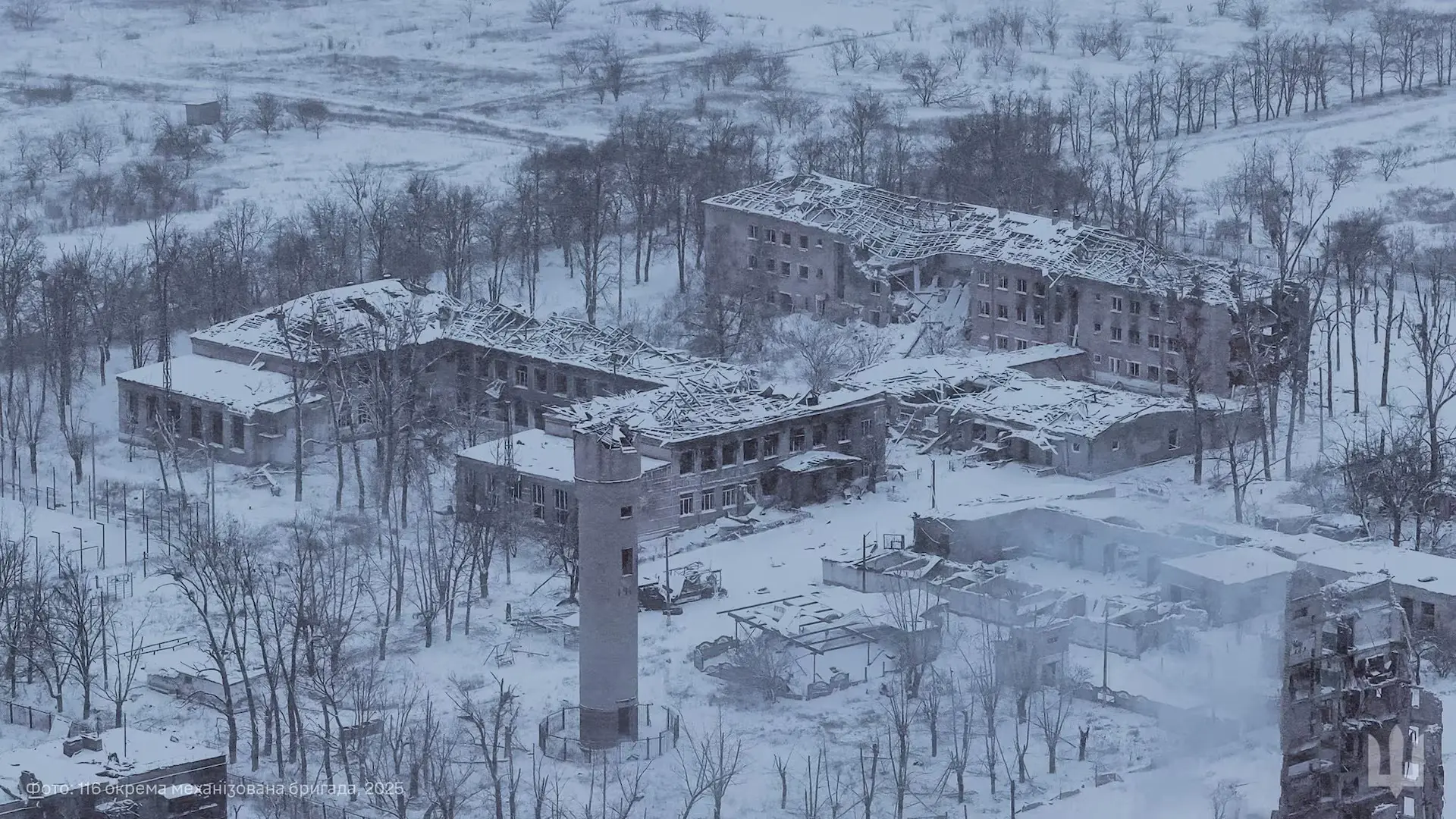 Destroyed buildings in winter snow, aerial view