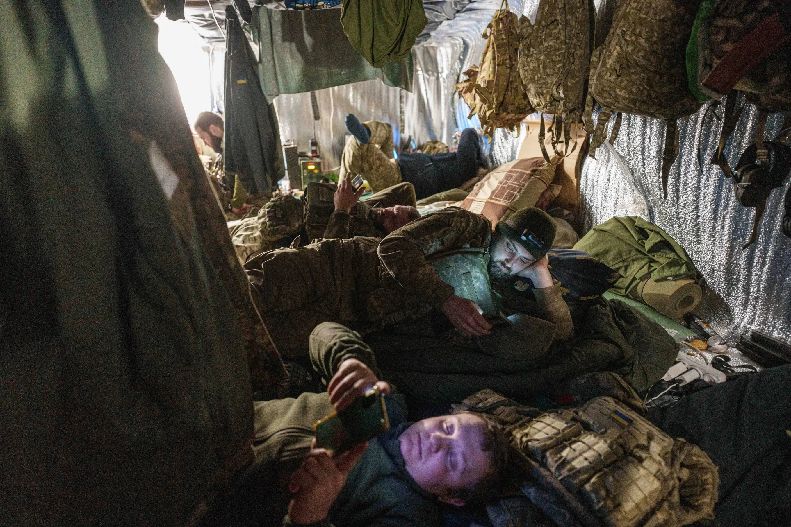 Soldiers sleeping in cramped dugout bunker