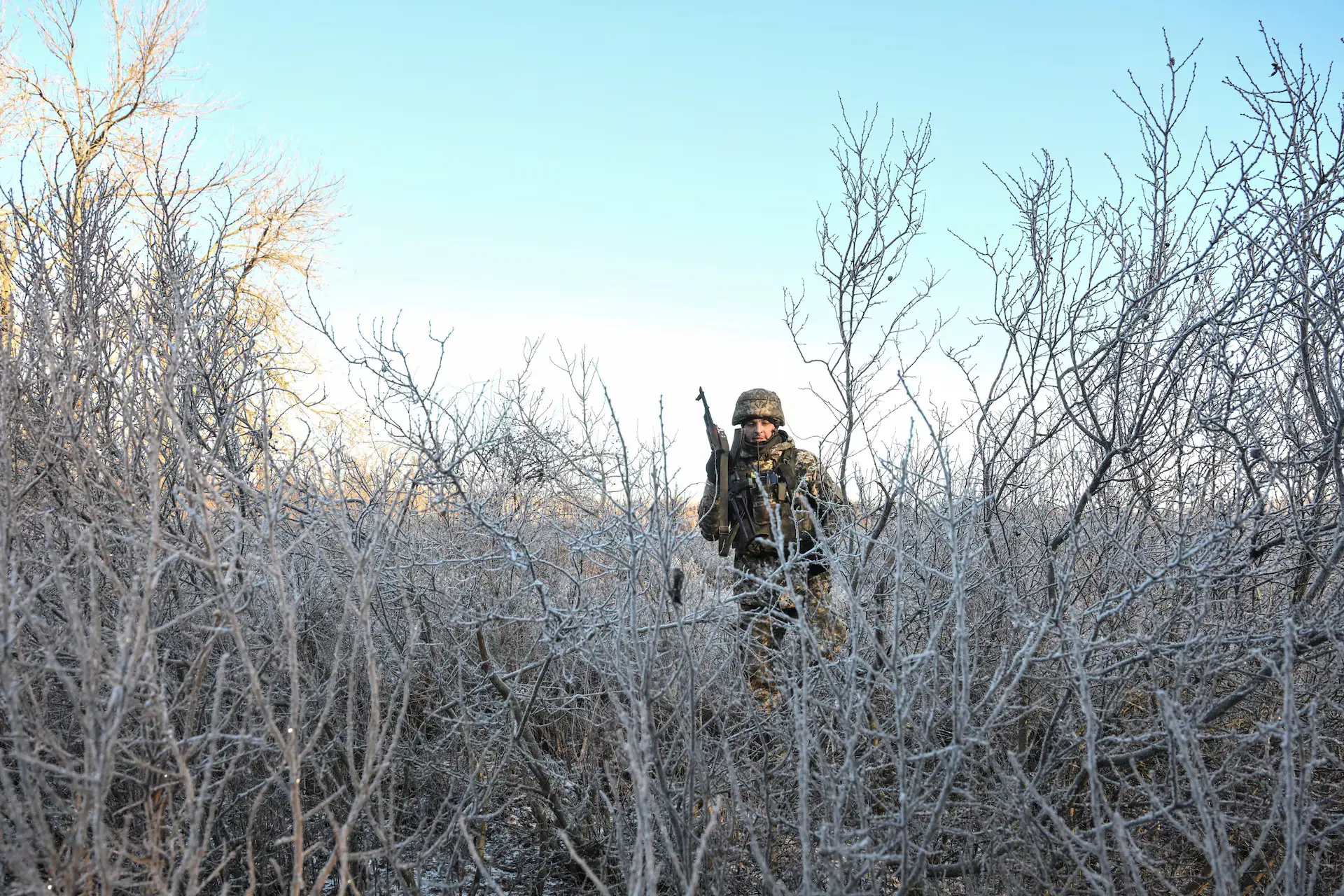 Soldier among frost-covered branches in winter